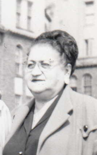 black and white photo of a woman in a suit standing outdoors 